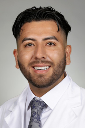 Portrait of medical student Alfredo Lopez Aguirre in white coat and smiling