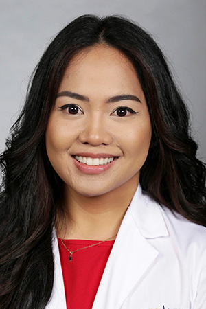 Portrait of medical student Christi Candido in white coat and smiling