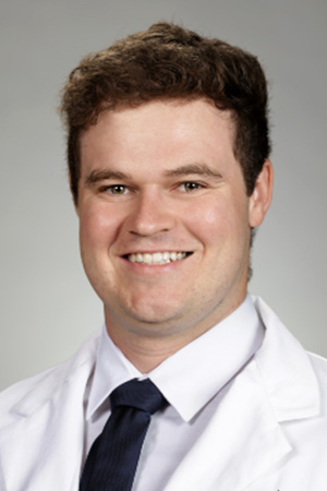 Portrait of medical student Jacob Wilson in white coat and smiling