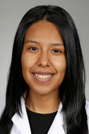 Portrait of medical student Jasmin Dominguez Cervantes in white coat and smiling