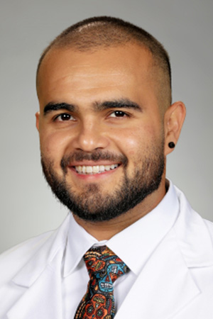 Portrait of medical student Juan Novoa in white coat and smiling