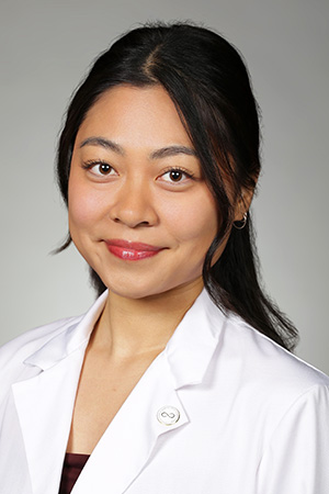 Portrait of medical student Angelina Phan in white coat and smiling