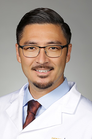 Portrait of medical student Danny Provost in white coat and smiling