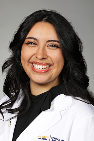 Portrait of medical student Daveena Morales in white coat and smiling