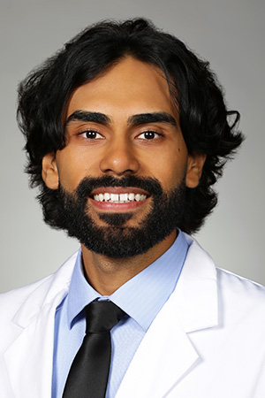 Portrait of medical student Ismael Rosales in white coat and smiling