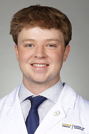 Portrait of medical student Jaden Todd-Nelson in white coat and smiling