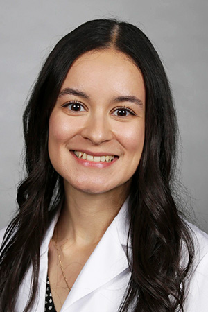 Portrait of medical student Melanie Venegas in white coat and smiling