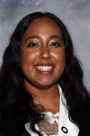 Portrait of medical student Praveena Singh in white coat and smiling