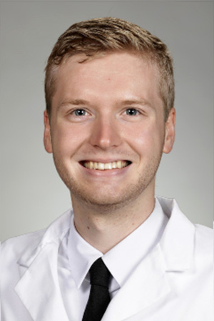 Portrait of medical student Callen Moon in white coat and smiling