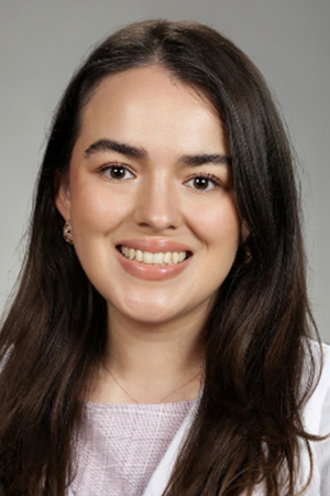 Portrait of medical student Daisy Franco-Gutierrez in white coat and smiling