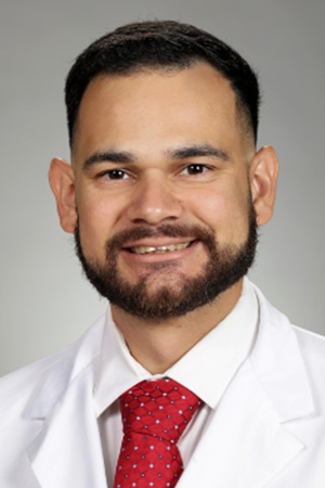 Portrait of medical student Pedro Hernandez in white coat and smiling