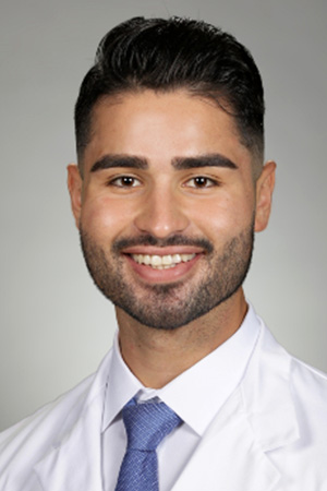 Portrait of medical student Robert Ramiro Hernandez in white coat and smiling