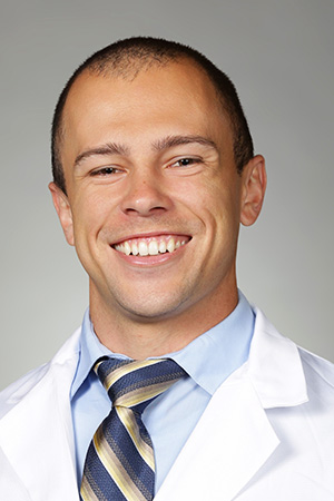 Portrait of medical student Ethan Pike in white coat and smiling