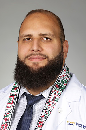 Portrait of medical student Waseem Musleh in white coat and smiling