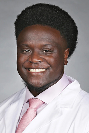 Portrait of medical student Demond Rodgers Jr. in white coat and smiling