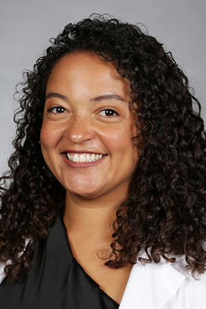 Portrait of medical student Marissa Harris in white coat and smiling