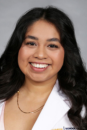 Portrait of medical student Martha Avila-Zavala in white coat and smiling