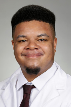 Portrait of medical student Andre Brown in white coat and smiling