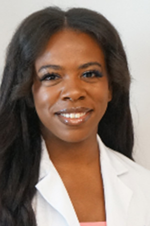Portrait of medical student Jala Beasley-Williams in white coat and smiling