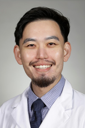 Portrait of medical student Joshua Kim in white coat and smiling
