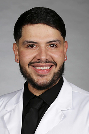 Portrait of medical student Raul Curiel in white coat and smiling