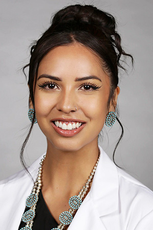 Portrait of medical student Ashley Martinez in white coat and smiling