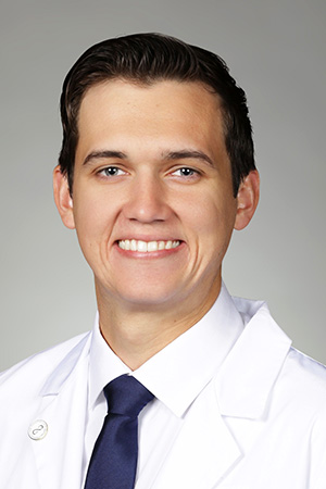 Portrait of medical student Landon Swopes in white coat and smiling