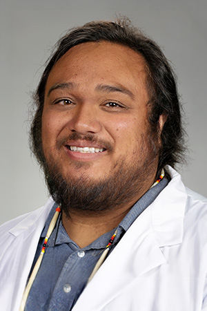 Portrait of medical student Leonard Almero in white coat and smiling