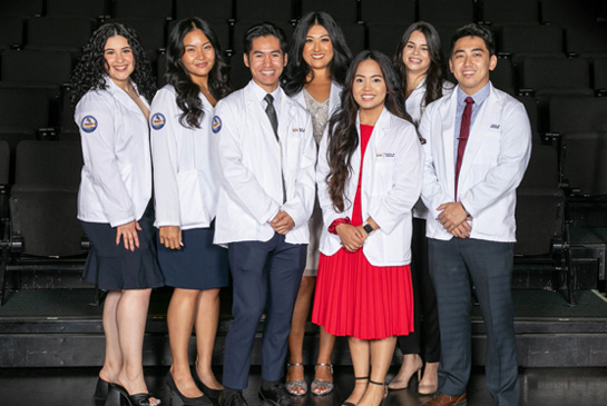 REACH medical students in white coats standing for a photo