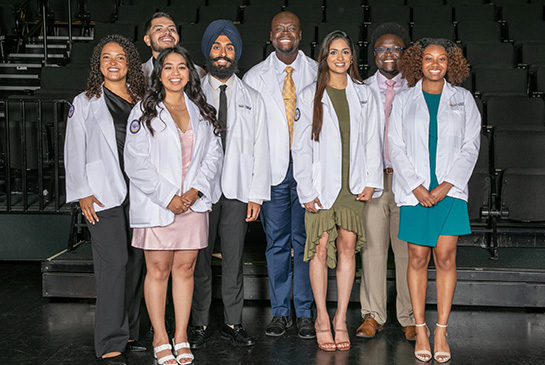 TEACH-MS medical students in white coats standing for a photo
