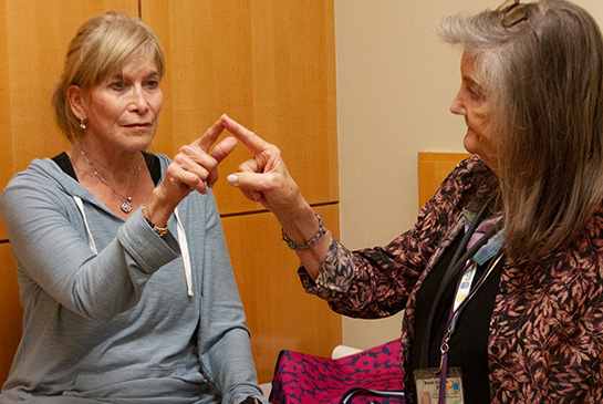 Randi Hagerman conducting a research study, touching fingertips with another adult
