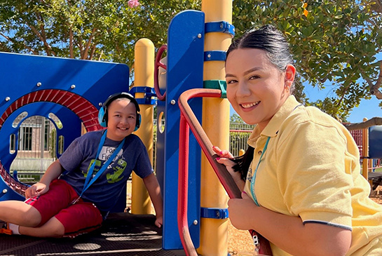 mind institute volunteer with child sitting on a playground