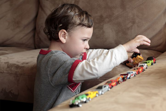 child lining up cars