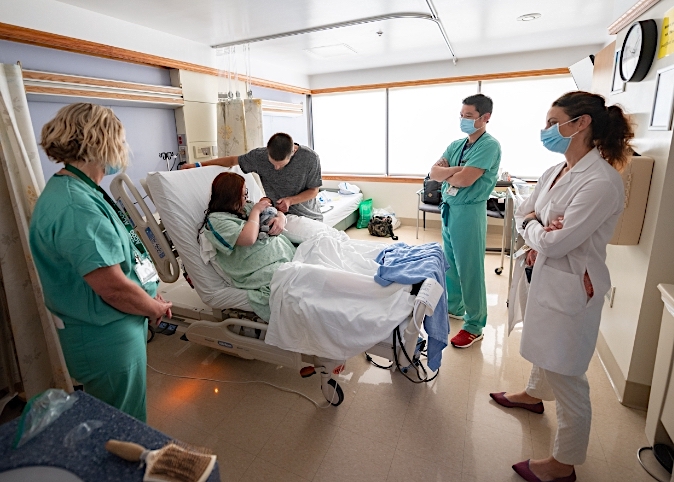 doctors and nurses with new family in birthing suite