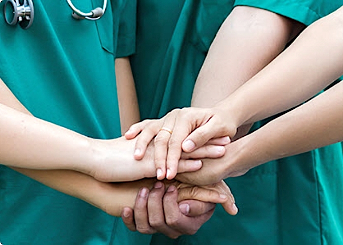 close up of doctors' hands stacked on top of each other