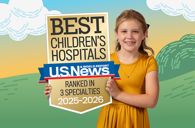 Child holding a U.S. News & World Report Best Children’s Hospitals ranked in 3 specialties 2025-2026 badge