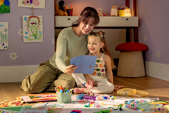 Pediatric patient and her mom surrounded by arts and crafts.