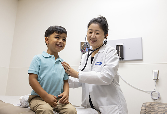 Doctor using a stethoscope to listen to a pediatric patient’s lungs