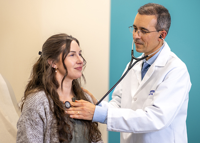 Primary care doctor Victor Baquero using a stethoscope to listen to a patient’s heart.