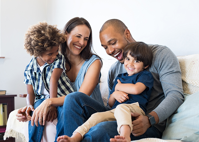 A happy family sitting on the couch in their home