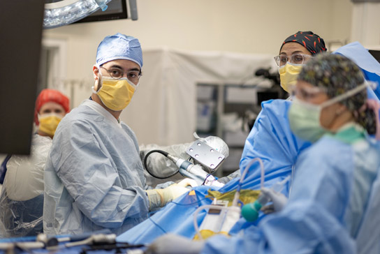 doctor performing a surgery with robotic assistant in the OR