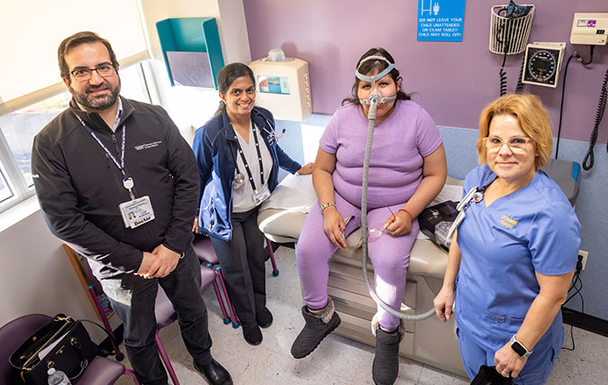 Pediatric Pulmonary team with female teen patient wearing a cpap mask in clinic