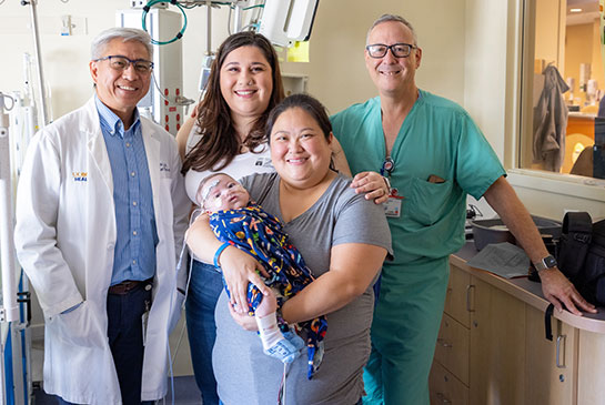 Pediatric cardiology patient with 2 women and 2 physicians, one in gown and the other in white coat