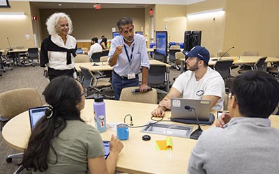 Thursday Didactics and Conference, students sit and listens while standing instructors explain lesson.