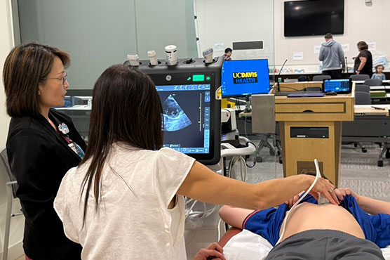 POCUS training with instructor and student scanning human patient or volunteer