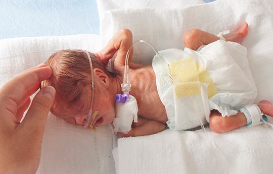 Premature baby in neonatal chamber with oxygen assistance tube