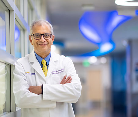 Satyan Lakshminrusimha in white coat in clinic hallway