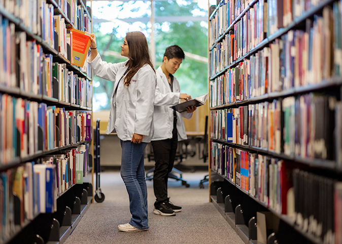 medical school students searching for books in a library