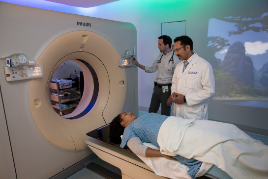 CT simulation procedure with clinicians preparing a patient for radiation treatment planning