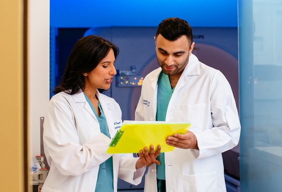 Physician teaches a resident during a CT simulation for radiation therapy planning.
